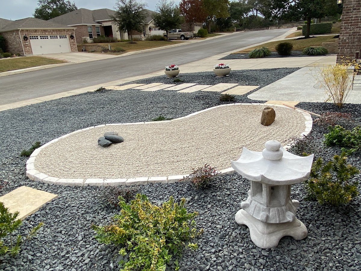 Driveway zen garden with raked gravel and ornamental plantings