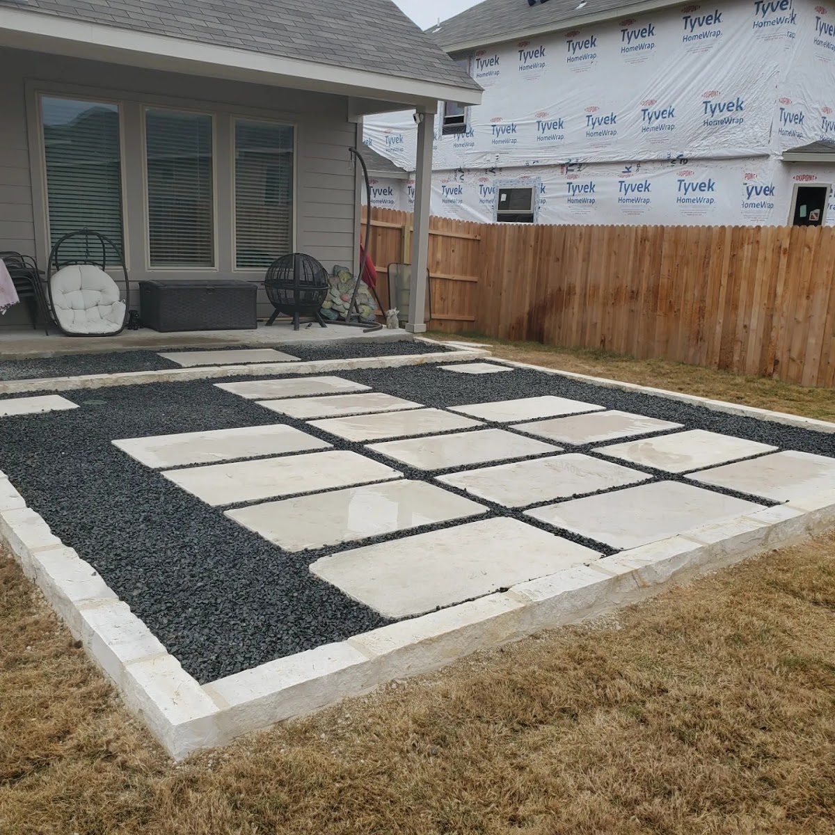 Modern limestone paver patio with dark decorative gravel grid