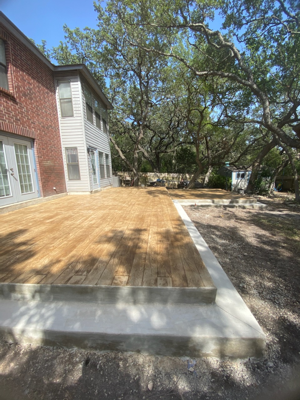 Large wood deck addition with oak canopy overhead